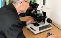光学顕微鏡で花粉を数える高梨征雄さん（横浜市金沢区）