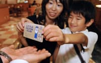 レストランで「リトル・ヒルトンクラブ」の会員カードを見せる子ども（東京都新宿区のヒルトン東京）