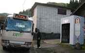 早朝、深谷集落の停留所でバスに乗る高齢者。待合所は住民が作った（青森県鯵ケ沢町）