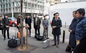 大阪地裁前で公判後に集会を開くNOON裁判弁護団（昨年12月、大阪市）