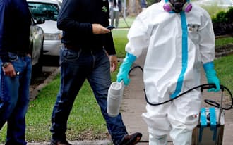 米国内でエボラの診断を受けた看護師の住居周辺で作業を終えた男性ら（12日、米テキサス州）=ゲッティ共同