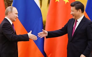 6月25日、中国の人民大会堂で会談したロシアのプーチン大統領(左)と中国の習主席=共同
