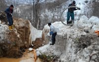 1メートル超の積雪のなか、漏水した管を掘り返す作業は難航した（3月、北海道古平町）
