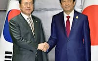 会談前に握手する文大統領(左)と安倍首相（24日、中国・成都）=共同
