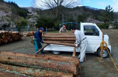 町民から買い取った木材をトラックからおろす町職員ら(4月、群馬県中之条町)