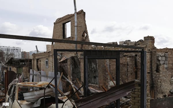激しい戦闘で破壊された建物。車は焼け焦げていた(4月12日、ウクライナ首都キーウ近郊ブチャ)=共同