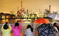 倉庫の屋上で工場の夜景を撮影するバスツアーの参加者(神奈川県川崎市)