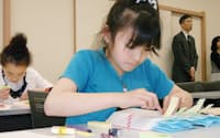 真剣な表情で辞書に付せんを張る小学生(東京都世田谷区)
