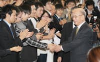 ノーベル化学賞受賞から一夜明け、学生らに拍手で迎えられる北海道大学の鈴木章名誉教授(7日午前、札幌市北区)
