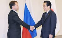 日ロ首脳会談を前に握手するロシアのメドベージェフ大統領(左)と菅首相(13日、横浜市西区)=代表撮影