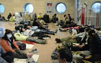 カイロ国際空港で足止めになり、ロビーの床で横になる日本人の団体旅行客（30日）=共同