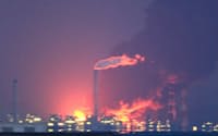 煙を上げる千葉県市原市のコスモ石油千葉製油所(11日午後、東京都江東区から)
