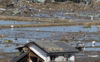津波で壊れた家屋と列車(12日午後、福島県新地町)
