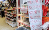 電池やカップ麺などの品切れを知らせる商店の張り紙(15日午前、東京都荒川区)