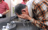 洗髪後に自分で顔を洗う男性客(大阪市中央区のターニング）