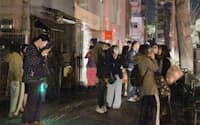 強い地震で建物の外に避難した人たち(7日夜、仙台市青葉区)=写真　塩山賢
