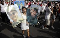 フィデル、ラウルのカストロ兄弟の写真を手に行進する市民(4月16日、ハバナ市内の革命広場)