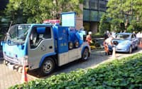電気自動車「リーフ」(奥)に充電する日産自動車が開発した救援車（6日、東京都港区）=共同