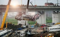 高速鉄道事故現場の高架橋から下ろされる車両の一部（24日、中国浙江省温州市）=共同