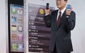 発売イベントで「iPhone 4S」を手にするKDDIの田中社長(14日、東京都渋谷区)