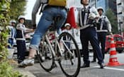 違反自転車の取り締まりを行う警察官(13日、東京都新宿区)