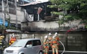 出火したアパートの消火活動をする消防隊員(6日、東京都新宿区)