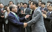 仮釈放後に開かれた会合で、民主党の小沢元代表(右)と握手する鈴木宗男氏（6日、衆院第2議員会館）=共同