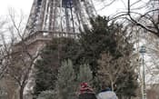 5日、フランスの首都パリで、雪の積もったエッフェル塔近くの公園を歩く旅行者=共同