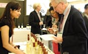 今年2月にヨーロッパで開催した、甲州ワインの周知イベントに訪れた外国人に説明する中央葡萄酒の醸造家、三沢彩奈さん（左）