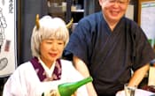 なじみ客から贈られた鬼嫁のかつらを付ける相沢孝香さん(左)と夫の一智さん(仙台市の「我流伊達屋敷」)