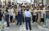 男女2人が刺された現場付近で足を止める通行人ら(10日、大阪市中央区)=共同