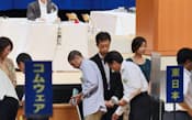 NTT労働組合の全国大会で議案に投票する組合員(12日、仙台市)