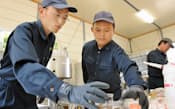 バイオディーゼル燃料作りに取り組む魚住さん(左)と石井さん