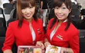 機内食を配るエアアジア・ジャパンのフライトアテンダント(19日、成田空港)