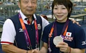 重量挙げ女子48キロ級で銀メダルを獲得し、父親の義行コーチ(左)と笑顔で握手する三宅宏実選手（28日、エクセル）=共同
