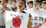 反日デモで、日の丸に「日本製品ボイコット」などと書き行進する人たち（13日、北京）=共同