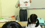 孫と同世代の子どもたちに英語を教える武藤さん(千葉県柏市)