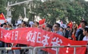 「日本を一つの省として中国に組み入れよ」との意味の横断幕を掲げる日本大使館前のデモ隊（18日）