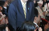 自民党の新総裁に選出され起立する安倍元首相(26日、自民党本部)