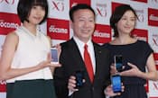 スマートフォンなどの新製品を発表し、記念写真に納まるNTTドコモの加藤社長（中）=10月11日午後、東京都中央区