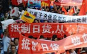 中国江蘇省蘇州で行われた反日デモで、「日本製品ボイコット」などと書かれた横断幕を掲げる参加者（9月）=共同