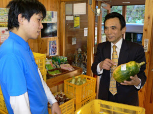 地場産の見慣れぬ野菜の食べ方を地元スタッフに聞く岡さん(右)(熊本県水上村)