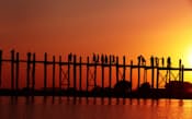 ミャンマー第2の都市マンダレー市郊外にある木の橋「ウーベイン橋」。夕暮れ時、全長1.2キロの橋を行き交う人々がシルエットで浮かび上がる