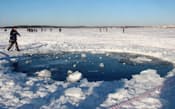 ロシア南部チェリャビンスク州の氷結したチェバルクリ湖にできた隕石落下の跡（16日）=共同