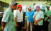 転職先のマレーシアの工場で従業員と話す早川さん(右から2人目)