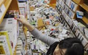 地震で散乱した本を片付ける市立津名図書館の職員(13日午後、兵庫県淡路市)