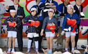 岩手県久慈市で海女の姿で観光をPRする「ちびっこあまちゃん隊」がお披露目された。祭りの来場者に餅をまいた（28日）=共同