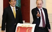 日本のロシアとの関係改善は中ロにくさびを打ち込むためと国際社会は受け止める(4月29日の首脳会談後、署名式に臨むロシアのプーチン大統領と安倍首相、モスクワ)=共同
