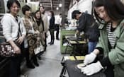 社員旅行で東大阪の中小企業「上田工房吉田製作所」を訪れ、銅鏡磨きを体験する人たち