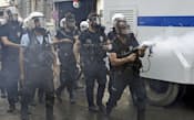 反政府デモ隊に向かって催涙弾を発射する警察官（6月16日、トルコ・イスタンブール）=共同
